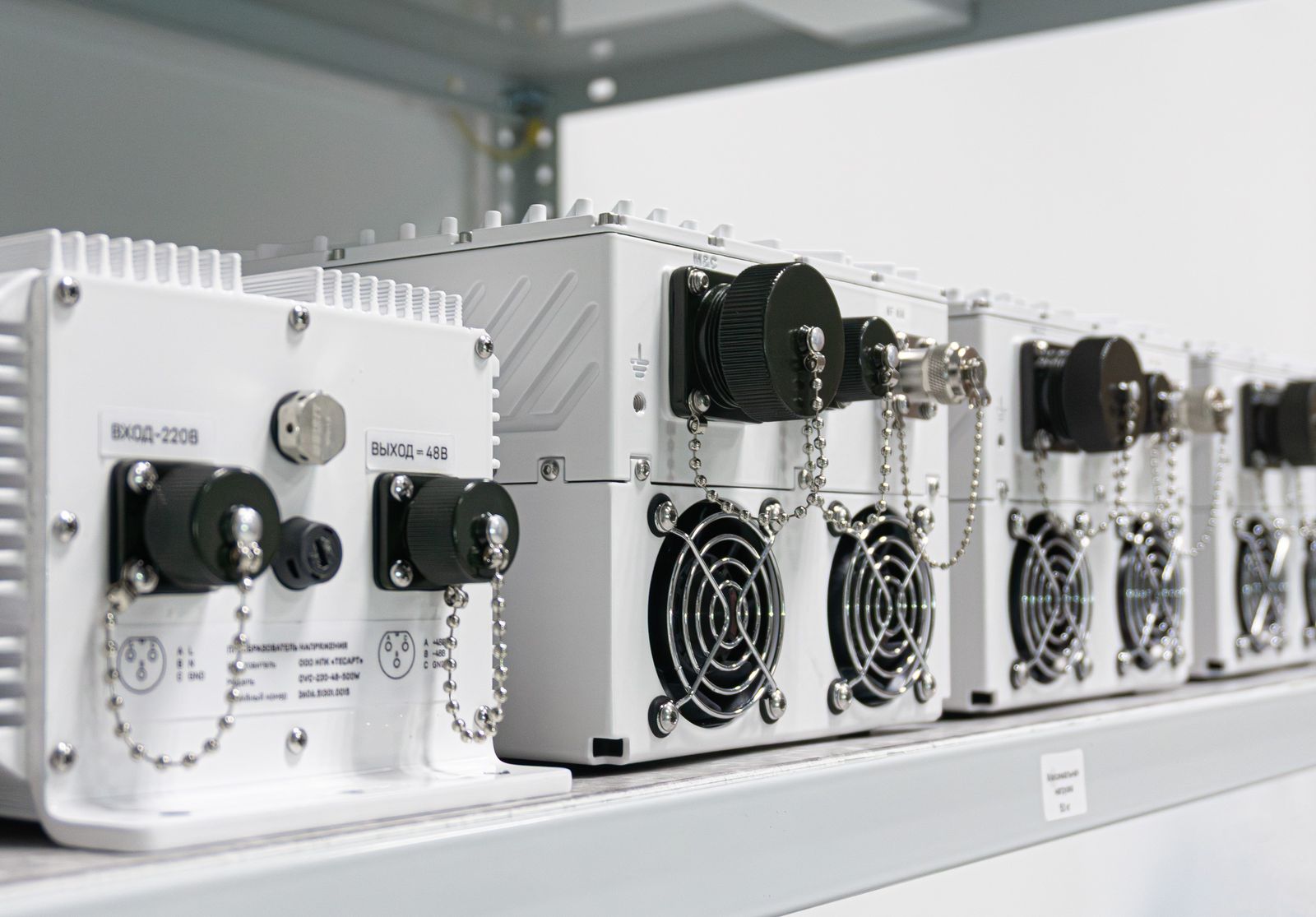 Row of TESART outdoor C-band BUC units with power supply on a production shelf